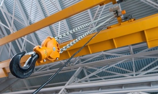 A warehouse overhead crane is used to handle heavy and bulky loads in a logistics facility