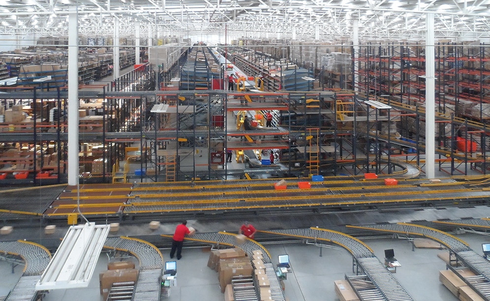 An enormous automated sorter with eight chutes categorises the boxed orders from the picking block