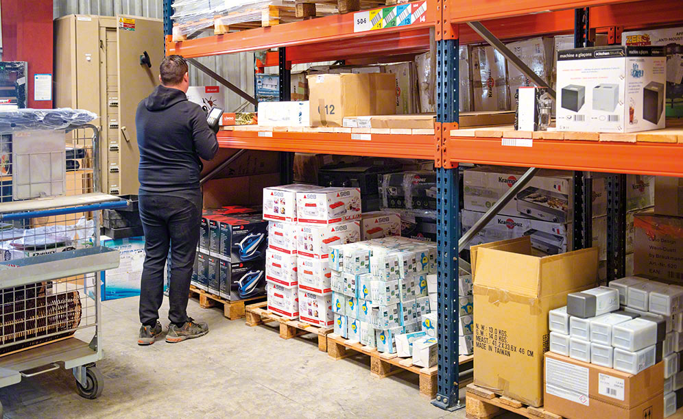An operator walks through the NEXECOM warehouse preparing orders