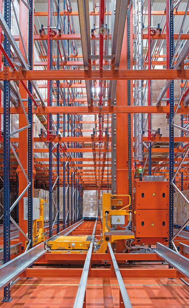 A twin-mast stacker crane circulates in each aisle that carries a Pallet Shuttle in its cradle A twin-mast stacker crane circulates in each aisle that carries a Pallet Shuttle in its cradle
