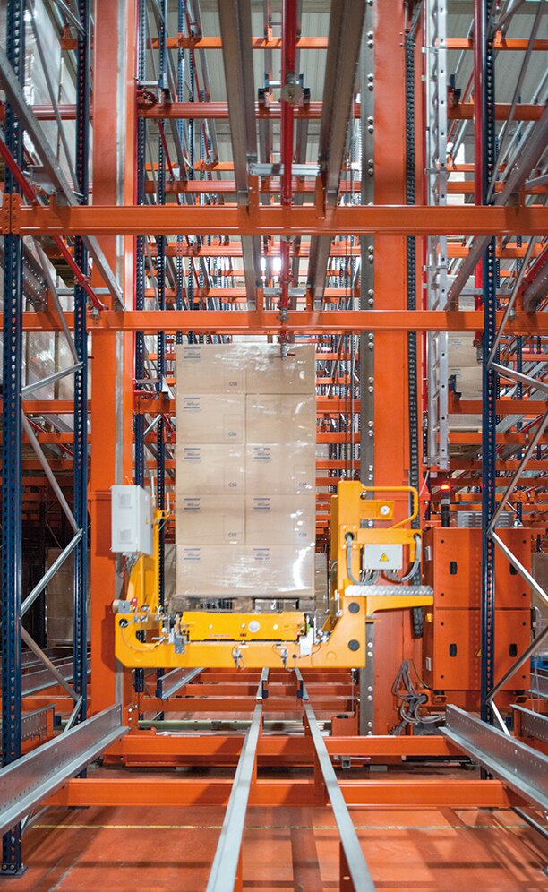 Once the stacker crane has placed itself in front of the assigned location, the shuttle is raised with the pallet on it and inserted into the channel Once the stacker crane has placed itself in front of the assigned location, the shuttle is raised with the pallet on it and inserted into the channel