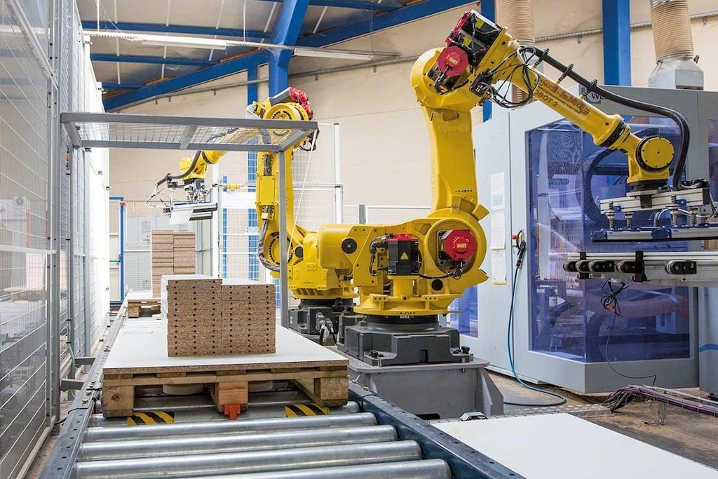 Mechanical arms palletise goods in a roboticised warehouse