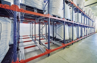 Pallets are deposited on a set of carts that slide along rails