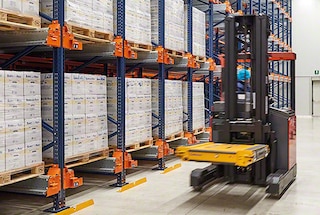With a forklift, the operator picks up the shuttle car and moves it to the assigned channel