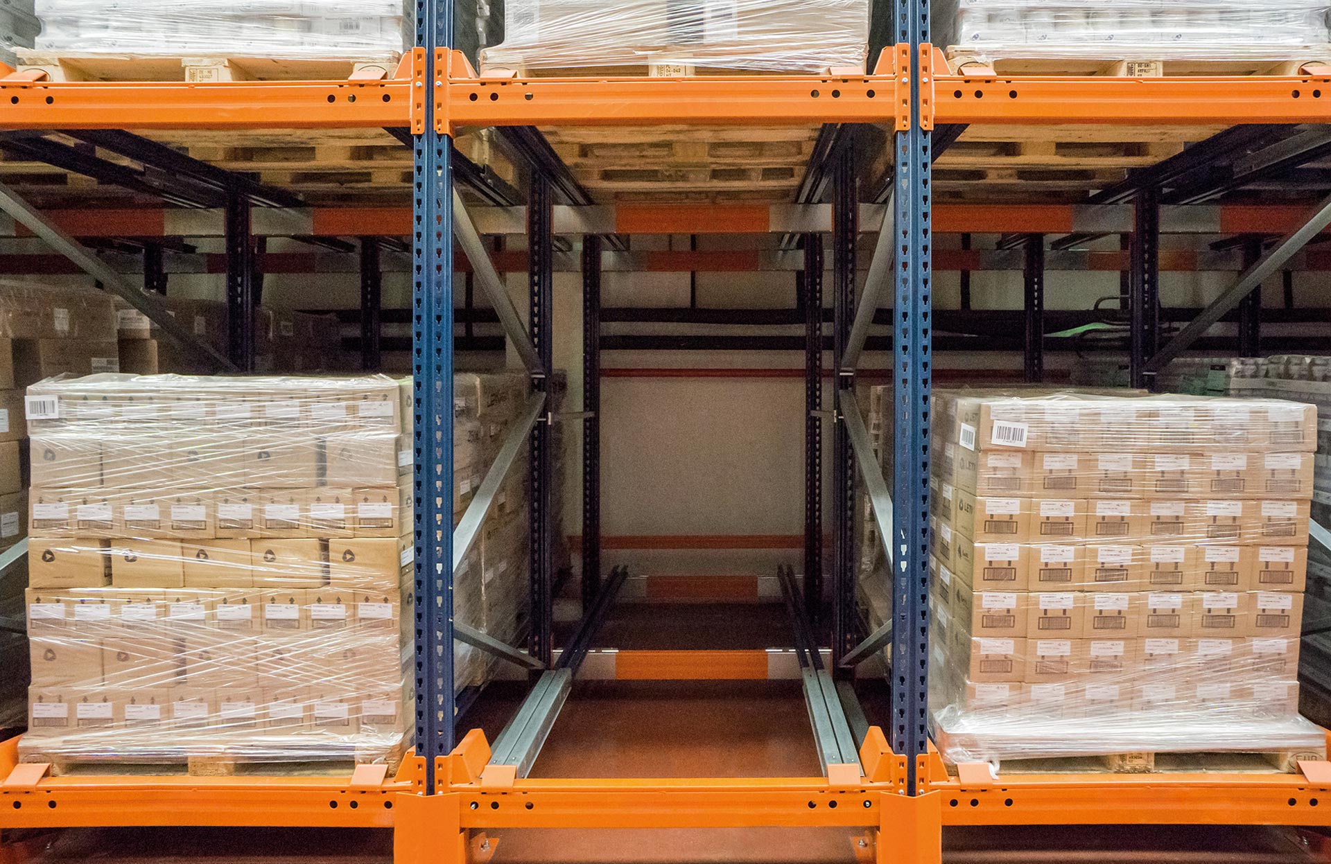 In push-back storage systems with carts, pallets are handled on the wide side