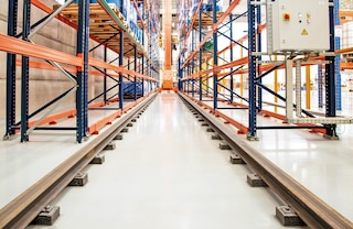 The automatic trilateral stacker crane travels along the aisle on a pair of lower rails