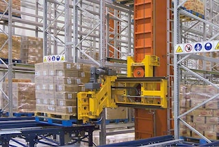The automatic trilateral stacker crane collects a pallet at the end of the storage aisle