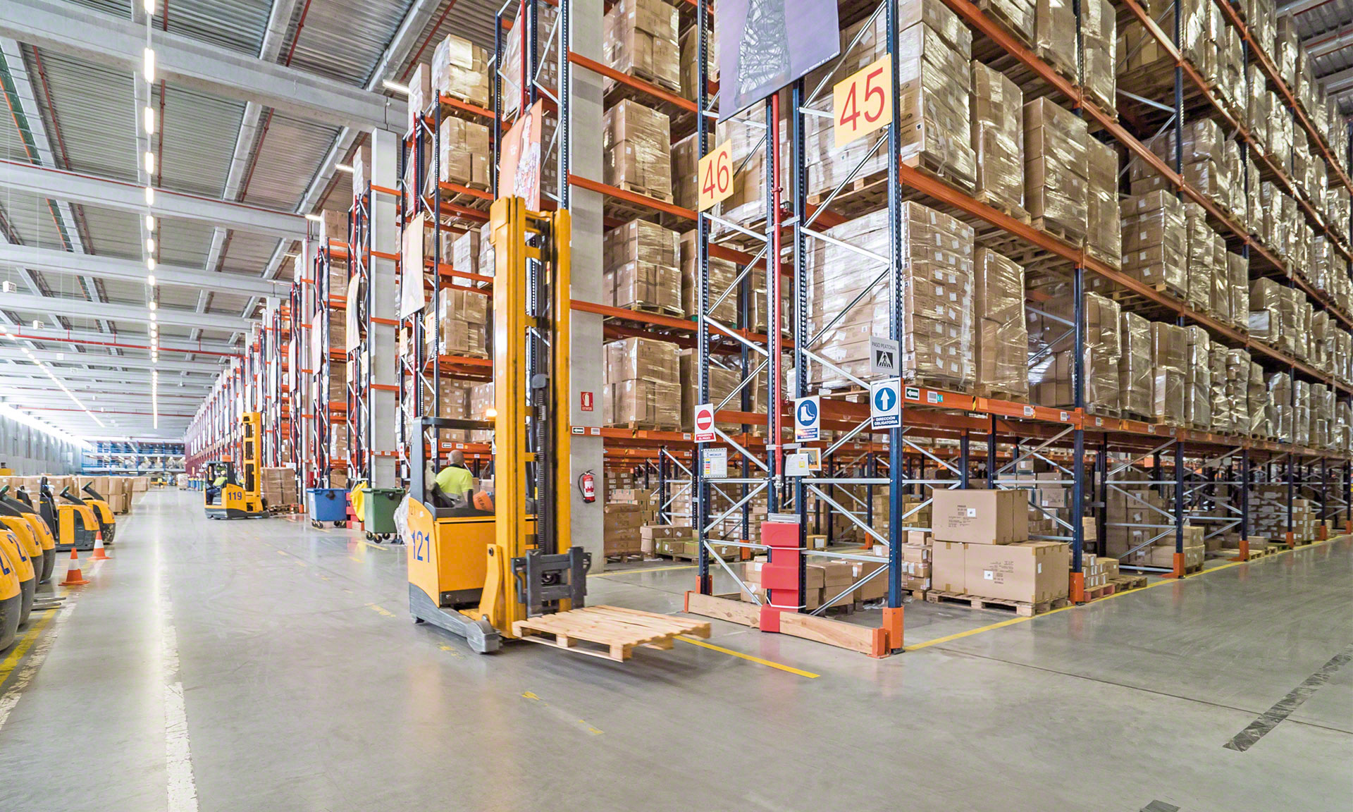 VNA (very narrow aisle) forklifts placing the pallets on the selective pallet racks VNA (very narrow aisle) forklifts placing the pallets on the selective pallet racks